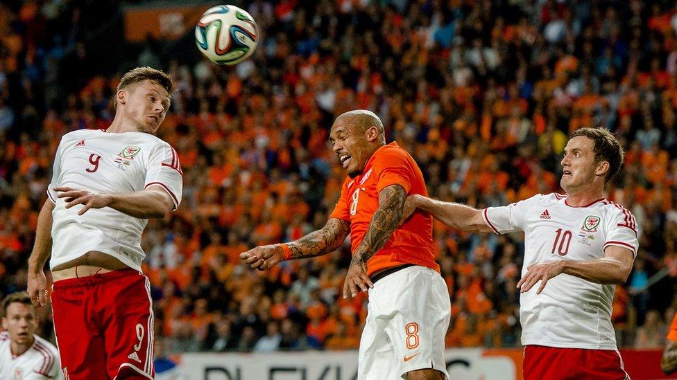 Nigel de Jong (C) of Netherlands vies with Wales players Simon Church (L) and Andy King