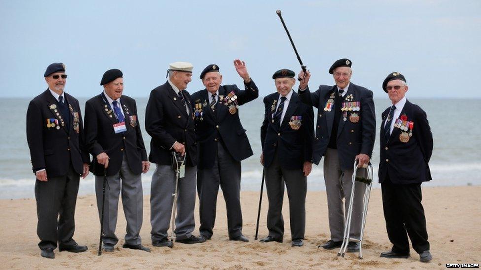 Seven British veterans standing on a beach in France