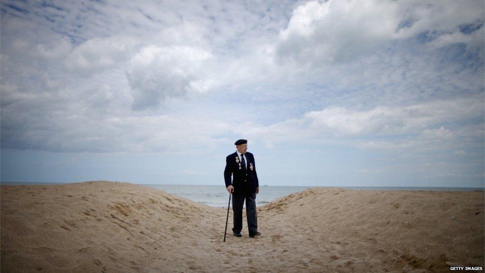 A British veteran walking alone on a beach