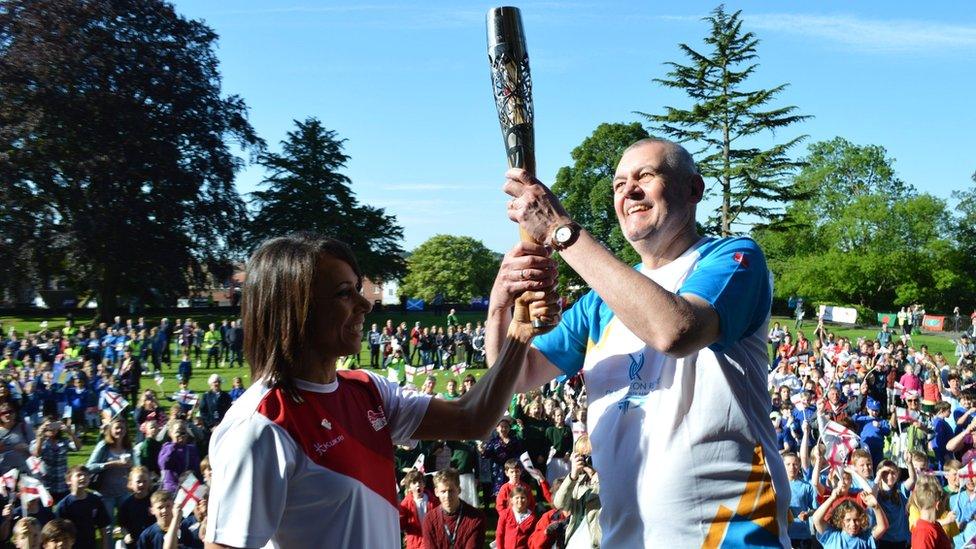 Dame Kelly Holmes hands the baton to Roland Gooding at Tonbridge Castle