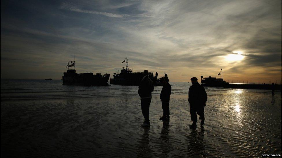 Landing craft and soldiers on a beach