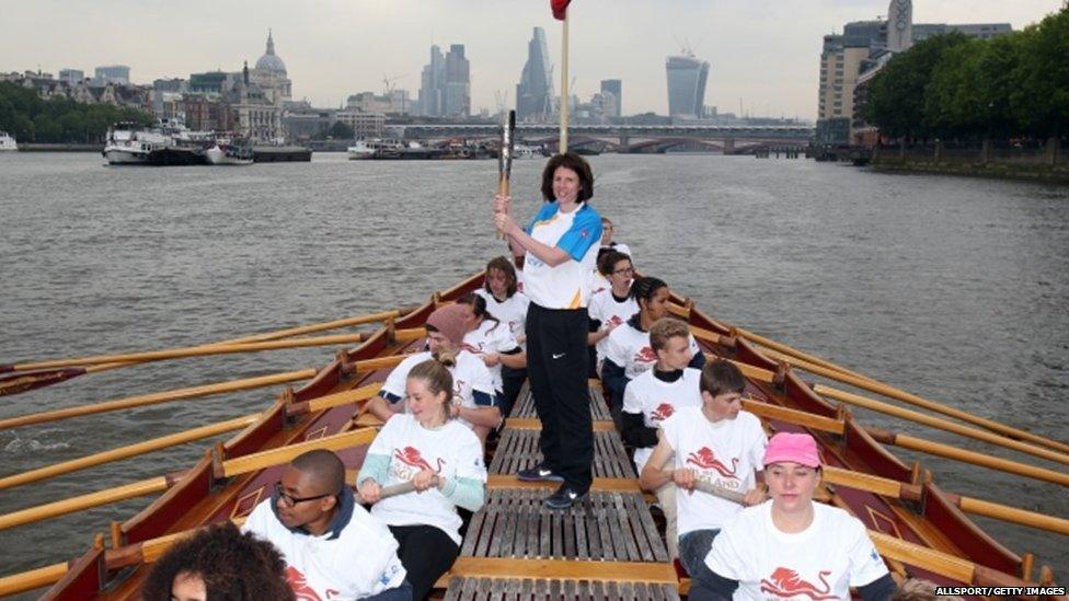 Baton bearer Rebecca Donnelly holds the Queens Baton on board the Gloriana as it makes its way down the River Thames