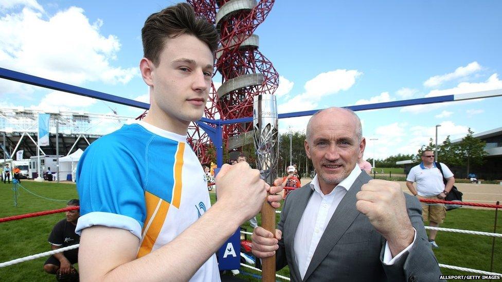 Baton bearer Jonathan Webb and Barry McGuigan hold the Queens Baton in front the Orbit tower