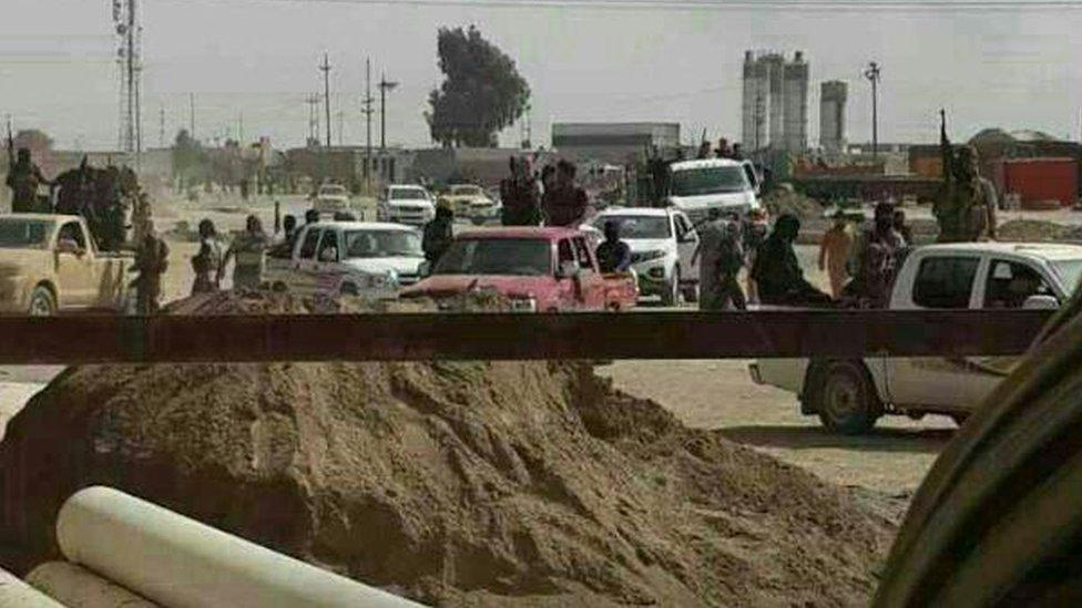 Gunmen are seen parading in vehicles with weapons in the Iraqi city of Tikrit