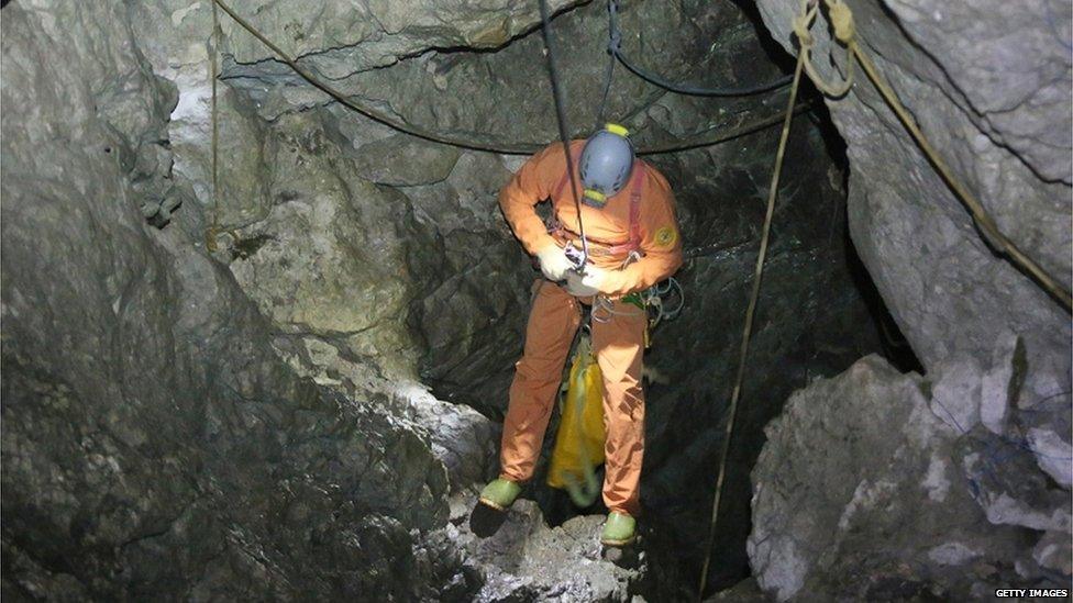 A rescuer descends into the Riesending cave