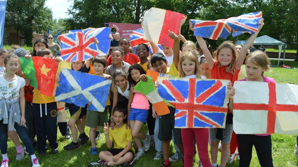 Children in Oxford hold commonwealth flags