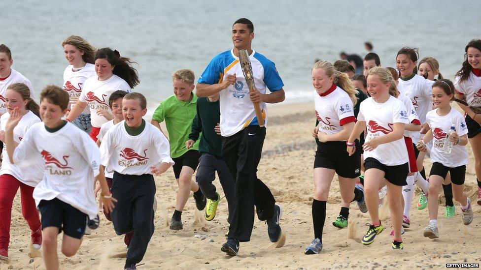 Olympic boxer Anthony Ogogo carries the Queen's Baton along the Lowestoft Seafront on 8 June 2014 in Suffolk