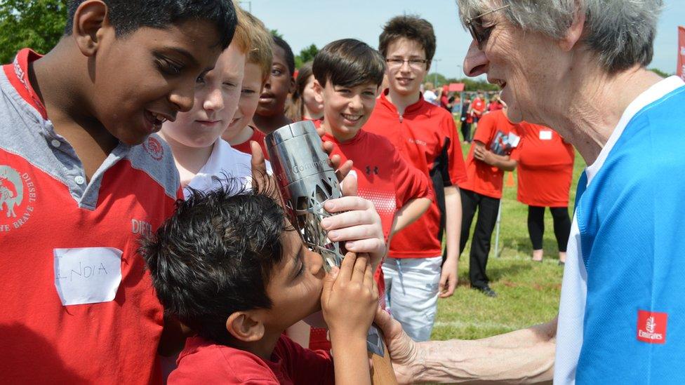 A boy kisses the baton in Oxford