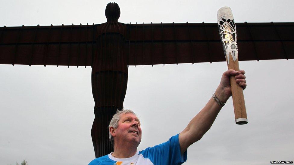 Baton-bearer Brendan Foster holding the Queen's Baton at the Angel of the North, Newcastle