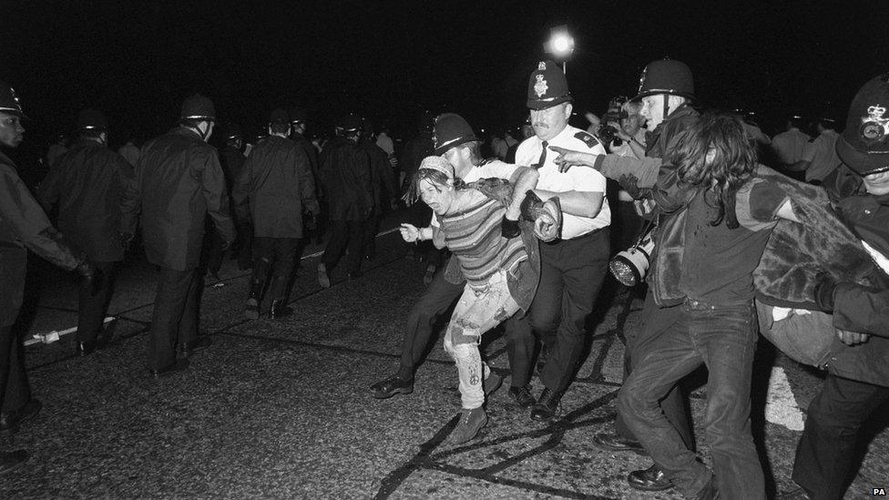 A vocal protest by a female hippy while being taken away by police at Amesbury, close to Stonehenge in June 1989