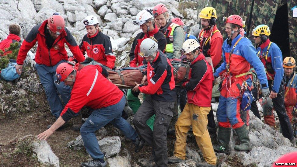 Stretcher carrying injured caver brought to surface.
