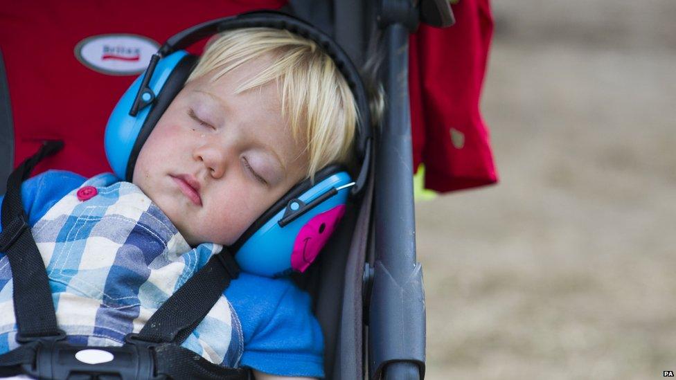 A toddler sleeps at Glastonbury festival