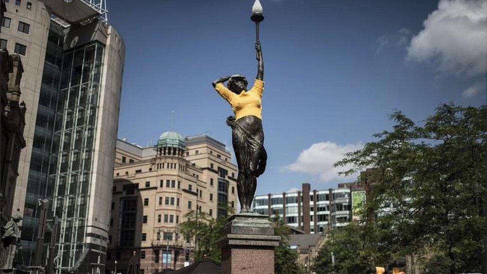 A statue, draped with a yellow cloth in reference of the Tour de France overall leader"s yellow jersey,