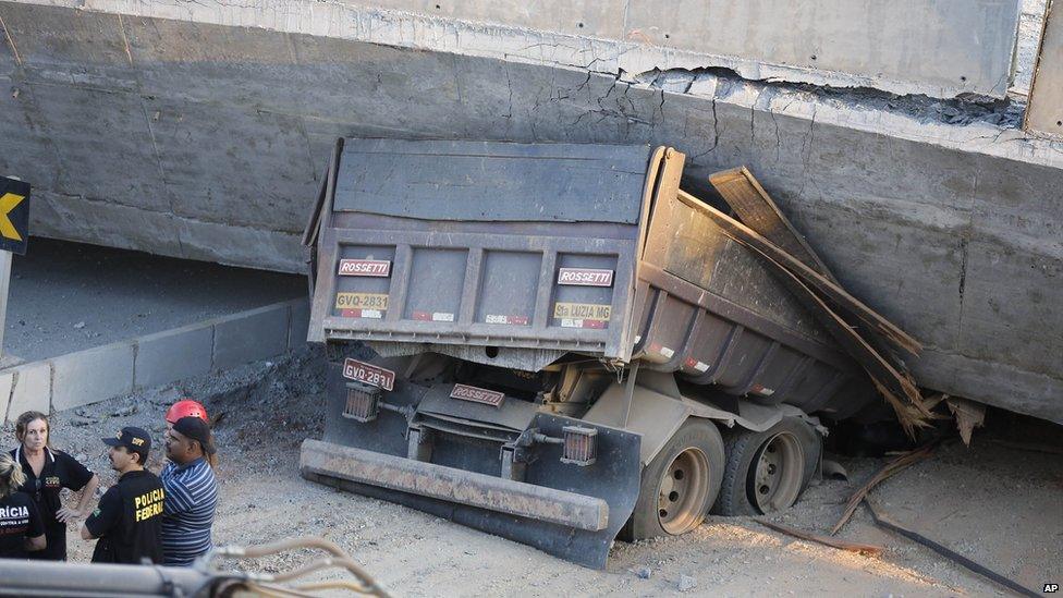 A truck is trapped underneath a collapsed bridge in Belo Horizonte, Brazil, on 3 July 2014.