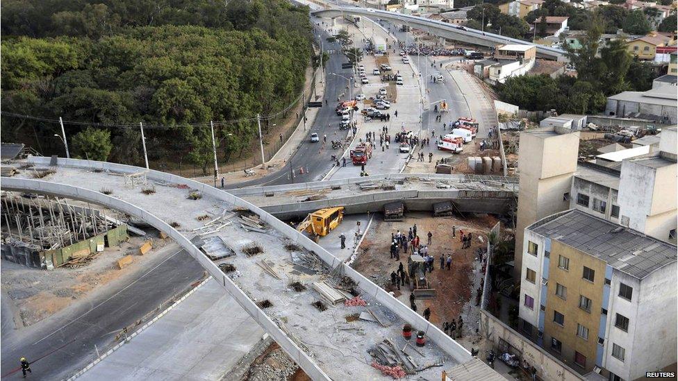 Rescue workers try to reach vehicles trapped underneath a bridge that collapsed while under construction in Belo Horizonte on 3 July 2014.