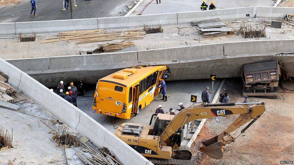 Rescue workers try to reach vehicles trapped underneath a bridge that collapsed while under construction in Belo Horizonte on 3 July 2014.