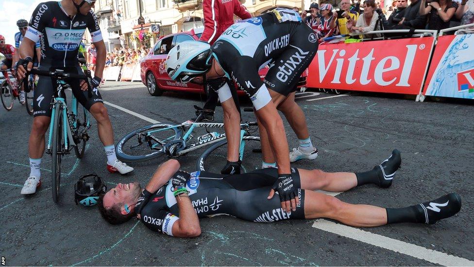 Mark Cavendish lies injured on the ground after crashing heavily during the sprint finish