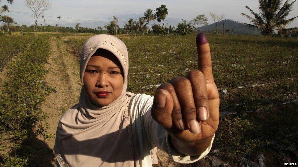 A voter poses for a picture after voting in Indonesia's presidential election in Brambang Darussalam, Bondowoso, East Java on 9 July, 2014