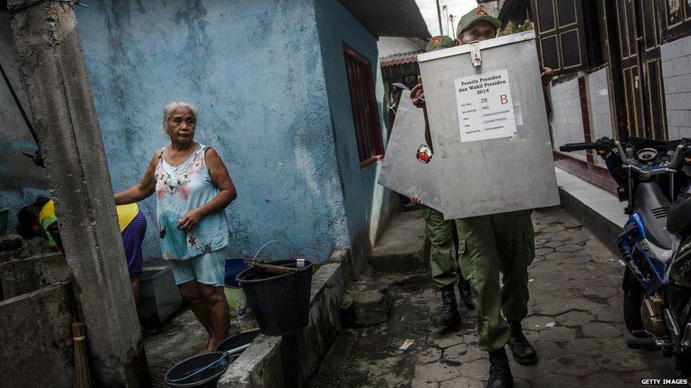 Election officers carry ballot boxes through slum area for distribution to the polling stations during preparations for the presidential election on 8 July, 2014 in Yogyakarta, Indonesia