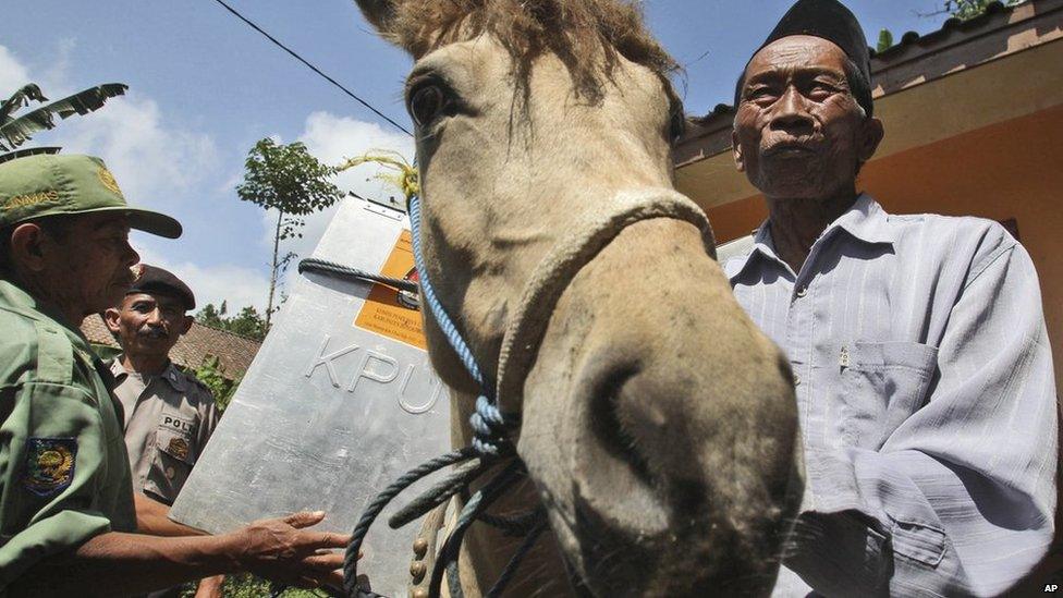 Electoral workers load a ballot box onto a horse as they prepare to distribute ballot boxes to polling stations in remote areas in Tlogosari, East Java, Indonesia, on Tuesday, 8 July, 2014