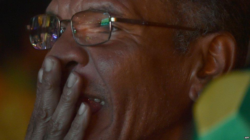 A Brazilian fan reacts while watching the 2014 FIFA World Cup semi-final match between Brazil and Germany on a public screen on the streets of Rio de Janeiro, Brazil on 8 July 2014