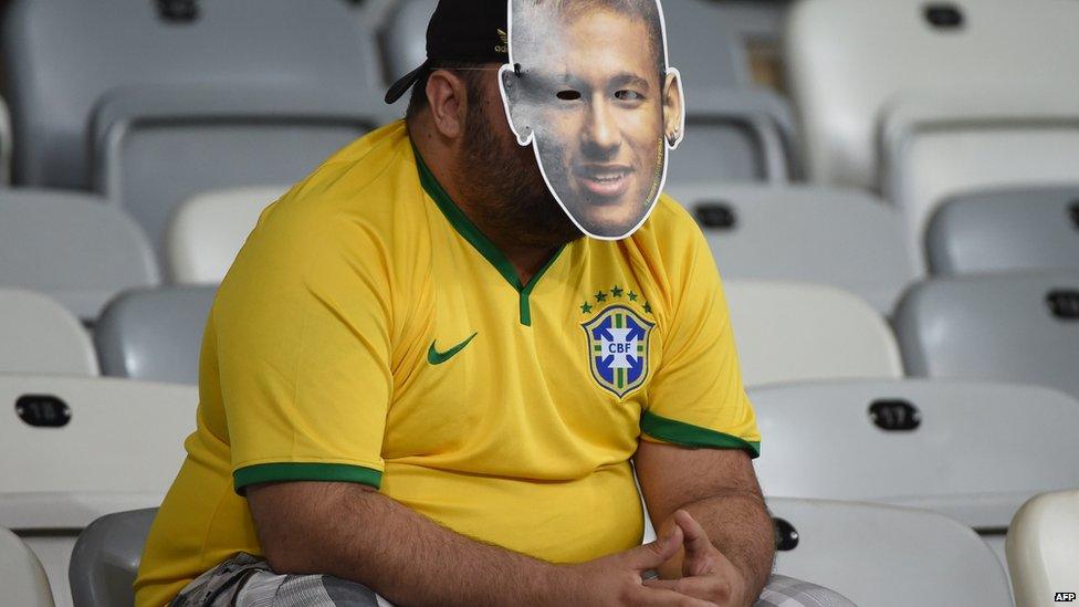 Brazilian supporters react after defeat in the semi-final football match between Brazil and Germany on 8 July 2014