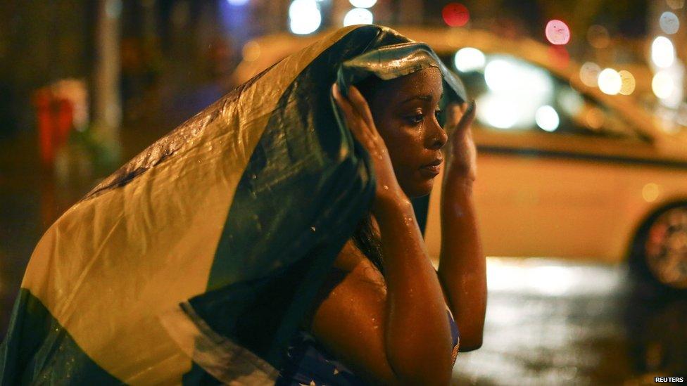 Brazilian supporters react after defeat in the semi-final football match between Brazil and Germany on 8 July 2014