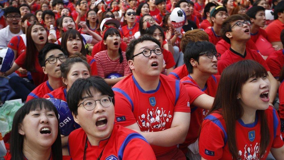 South Korean soccer fans react as they watch a live TV broadcast of their 2014 World Cup Group H soccer match against Russia in Seoul