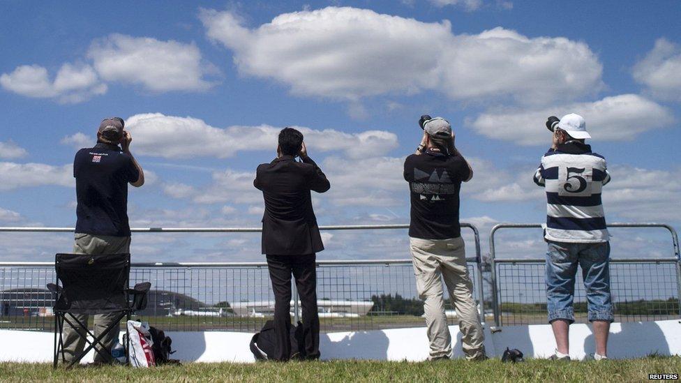 Four visitors to the Farnborough Airshow taking photographs