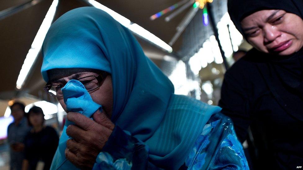 Relatives of passengers onboard Malaysia Airlines flight MH17 from Amsterdam cry as they arrive at Kuala Lumpur International Airport in Sepang on 18 July 2014