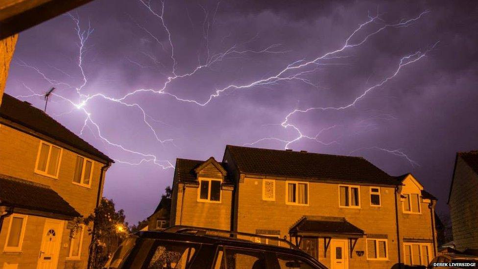 Lightning seen over houses at night