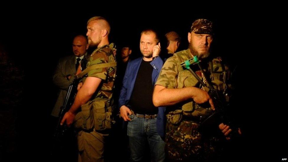 Self-proclaimed Prime Minister of the pro-Russian separatist "Donetsk People's Republic" Alexander Borodai (C) stands as he arrives on the site of the crash