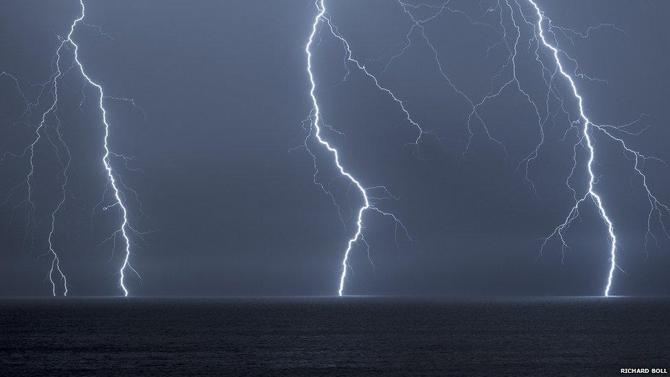 Three bolts of lightning hitting the sea