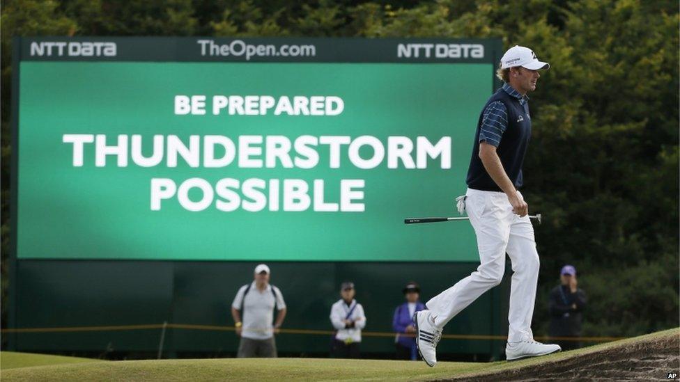 Golfer Brandt Snedeker walks past a sign which says: "Be prepared. Thunderstorm possible."