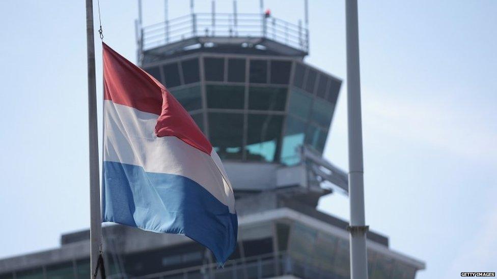 The Dutch flag flies at half mast at Amsterdam's Schiphol Airport in memory of those on Malaysia Flight MH17 (18 July 2014)