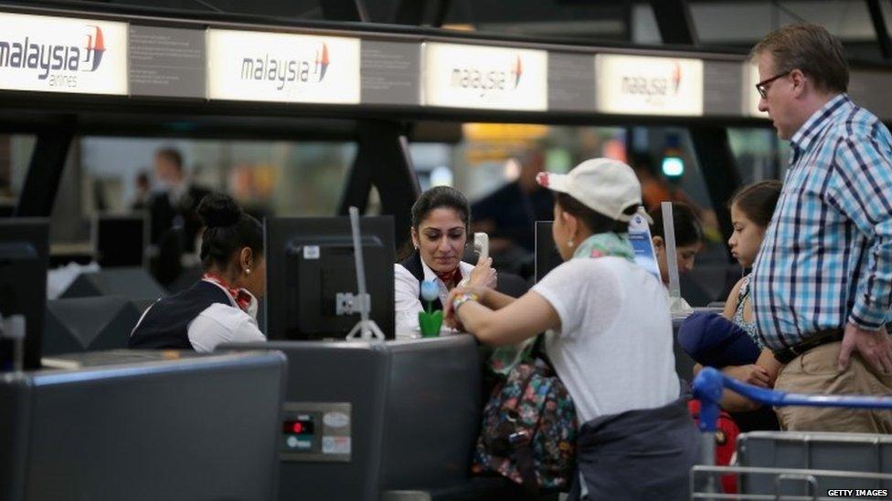 Passengers check in for an Air Malaysia flight at Amsterdam's Schiphol airport (18 July 2014)