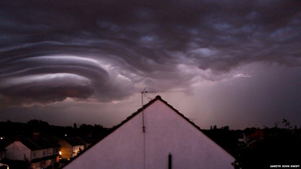 Lightning clouds over rooftops.