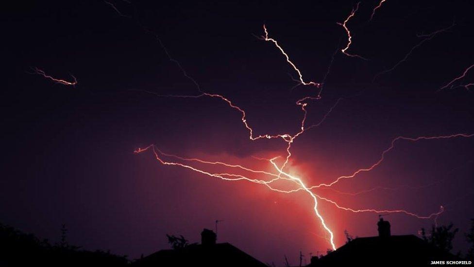 Lightning over rooftops.