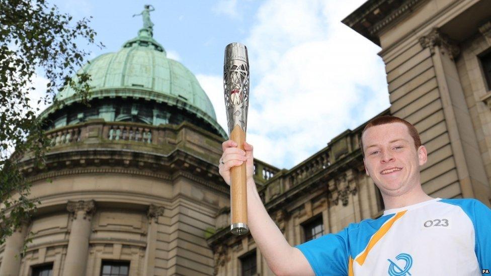 Batonbearer 023 Nathan Arbuckle carrying the Glasgow 2014 Queen"s Baton at the Mitchell Library in Glasgow.