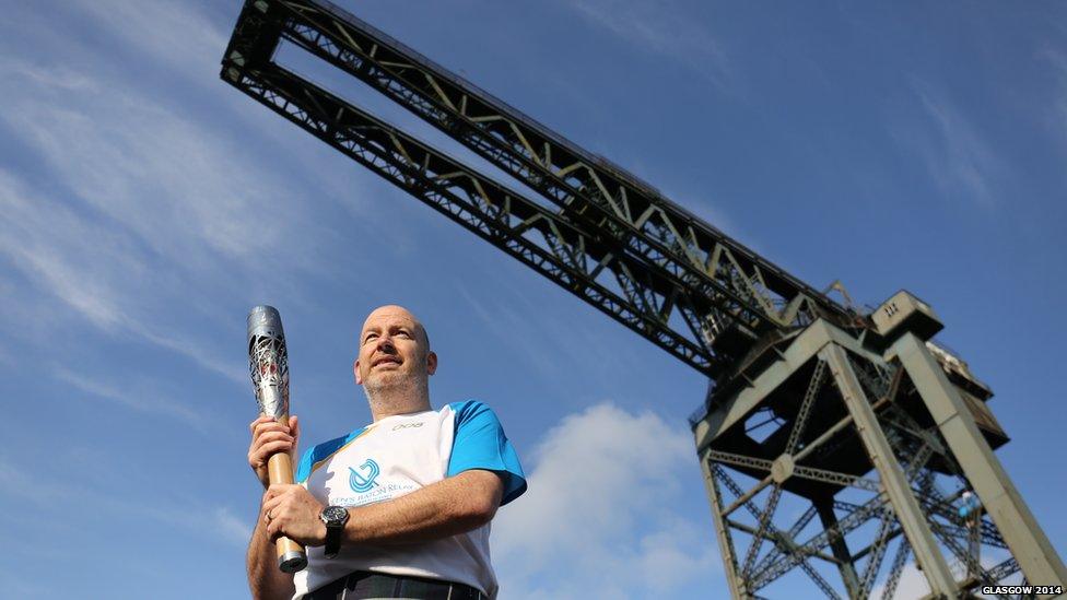 Mark O'Sullivan carries the Glasgow 2014 Queen's Baton at Finnieston Crane in Glasgow