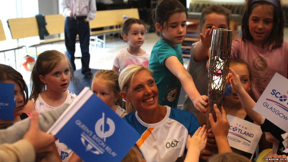 Baton bearer Lee McConnell carries the Glasgow 2014 Queen's Baton at Netherlee Primary School, Clarkston in East Renfrewshire.