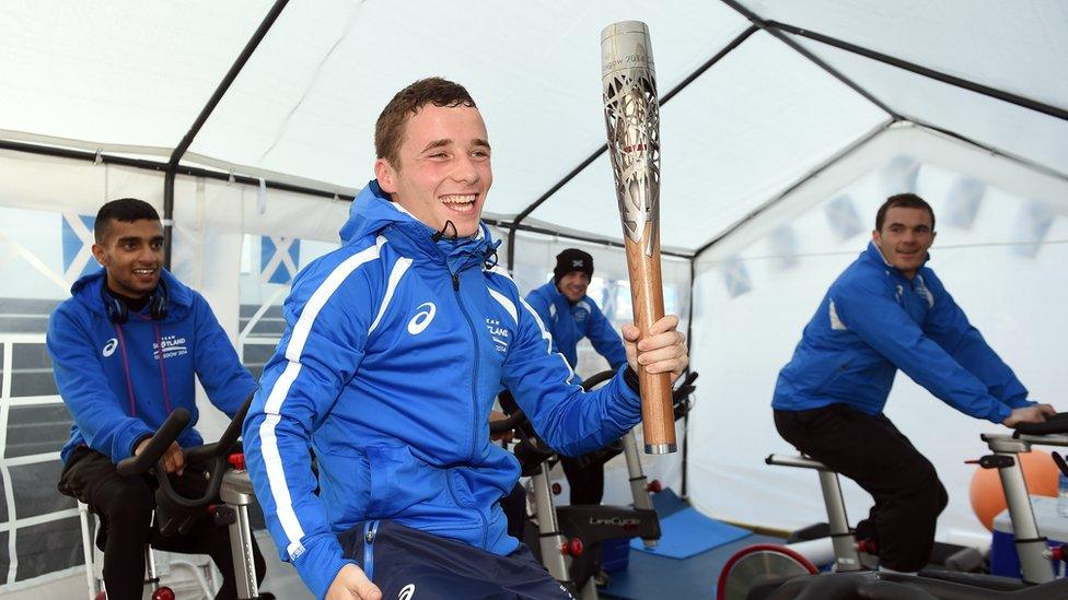 Team Scotland boxer Reece McFadden holds the Glasgow 2014 Queen's Baton as he tries to make weight for competition at the Commonwealth Games Athletes' Village in Glasgow.