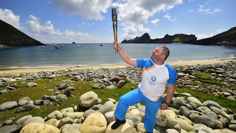 Baton bearer Colin Macleod holds the Glasgow 2014 Queen's Baton on the island of Hirta, the largest island in the St Kilda archipelago in the Outer Hebrides