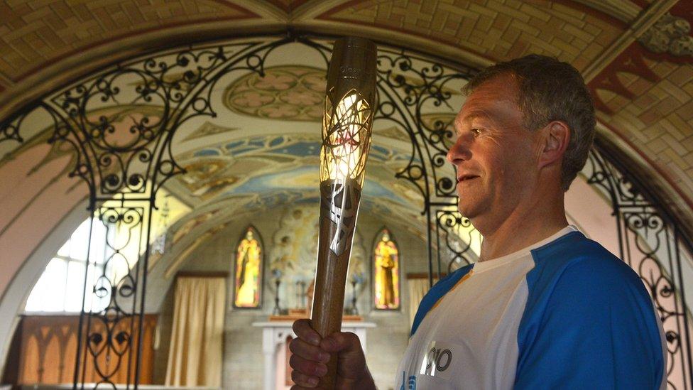 Batonbearer 010 Marty Flett with the Glasgow 2014 Queen's Baton inside the Italian Chapel, Lamb Holm on the Orkney Islands.