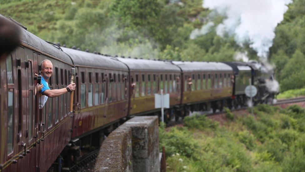 Baton bearer 040 David Sedgwick carries the Glasgow 2014 Queen's Baton through Glenfinnan in the Scottish Highlands.