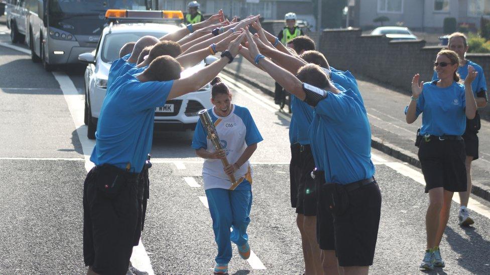 Police Scotland baton escorts create a guard of honour for a relay baton bearer.