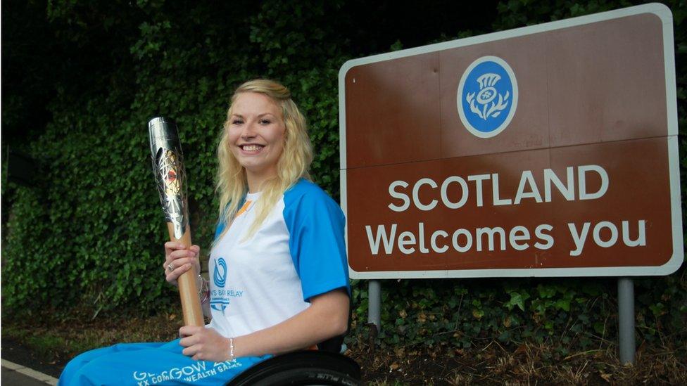 Baton bearer Samantha Kinghorn carries the Glasgow 2014 Queen's Baton through Coldstream in Scottish Borders