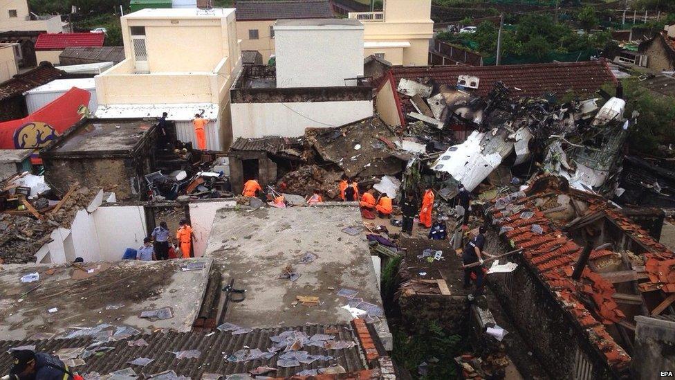 Police and soldiers guard the crash site of the TransAsia Airways plane on the Penghu Islands in the Taiwan Strait on 24 July 2014