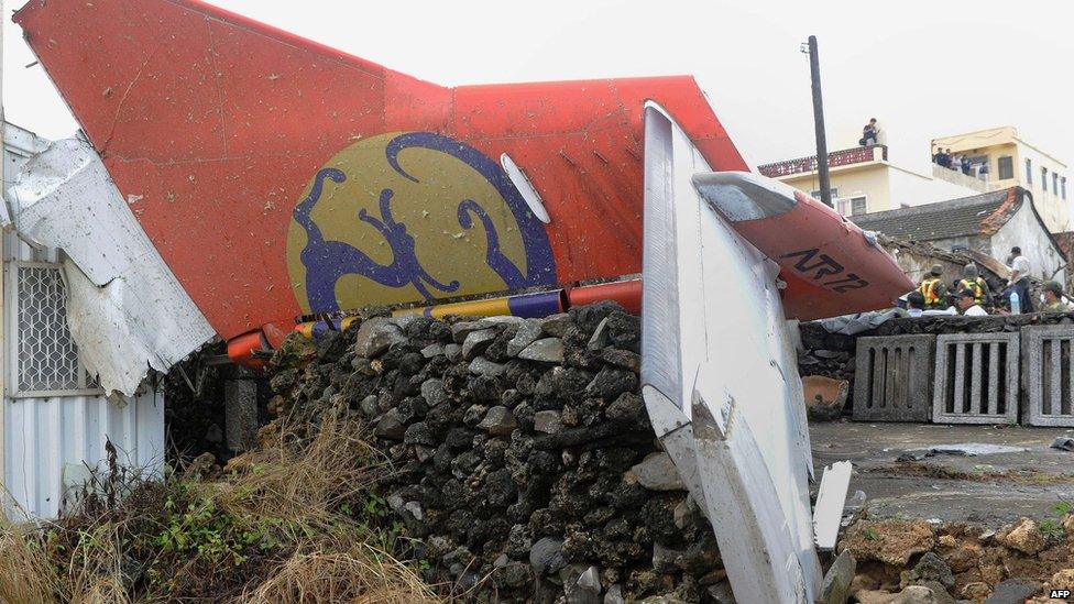 The tail section of TransAsia Airways flight GE222 is pictured as rescue workers and firefighters search through the wreckage on 24 July 2014