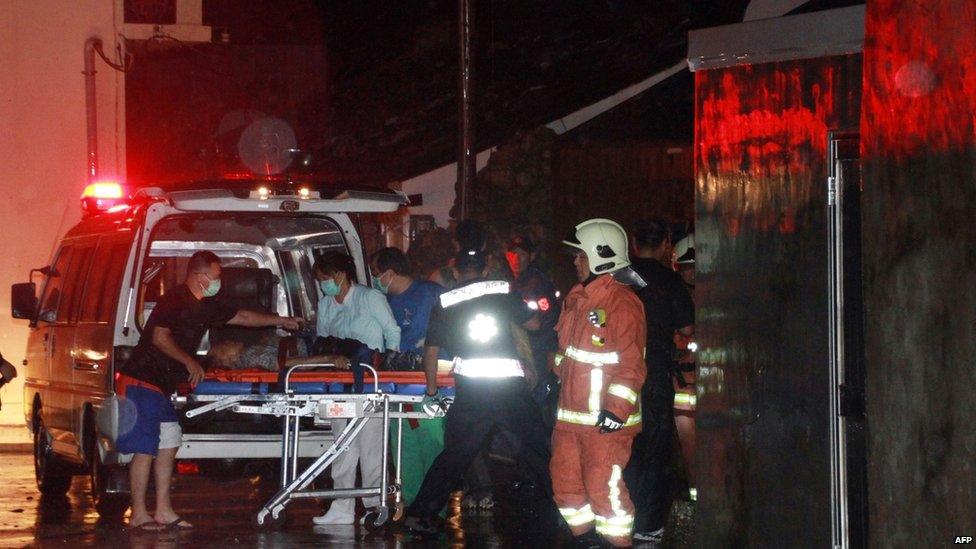 An injured passenger is helped by rescuers to get on an ambulance after the crash of the TransAsia Airways flight GE222 on 23 July 2014 in Penghu, Taiwan